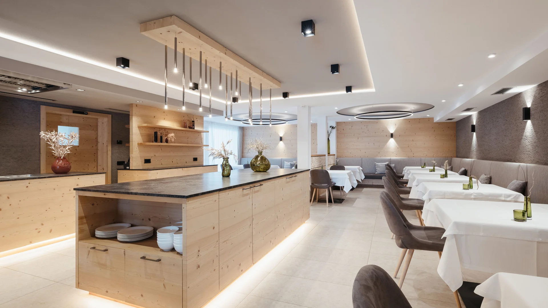 Zuhause auf Zeit im Hotel in Colfosco: Nature Hotel Delta Moderner Restaurantinnenraum mit Holzmöbeln und gedeckten Tischen