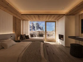 Zuhause auf Zeit im Hotel in Colfosco: Nature Hotel Delta Gemütliches Hotelzimmer mit Holzdecke und Bergblick vom Balkon