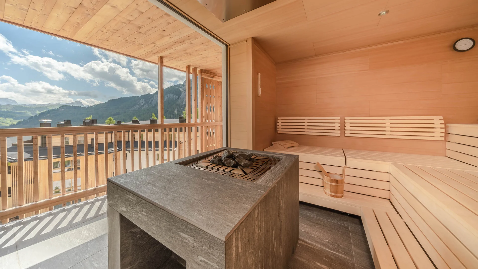 Zuhause auf Zeit im Hotel in Colfosco: Nature Hotel Delta Sauna mit Holzbänken und Bergblick durch große Fenster