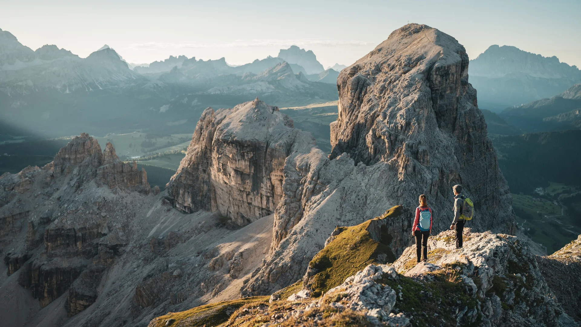 Zuhause auf Zeit im Hotel in Colfosco: Nature Hotel Delta Zwei Wanderer auf felsigem Bergpfad mit Blick auf große Felsformationen