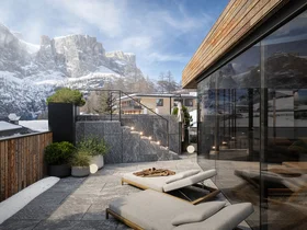 Zuhause auf Zeit im Hotel in Colfosco: Nature Hotel Delta Terrasse mit Liegestühlen und Bergblick im Schnee bei klarem Himmel